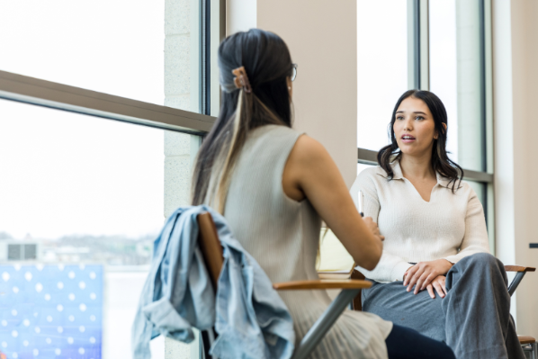 Image shows two colleagues having a meeting